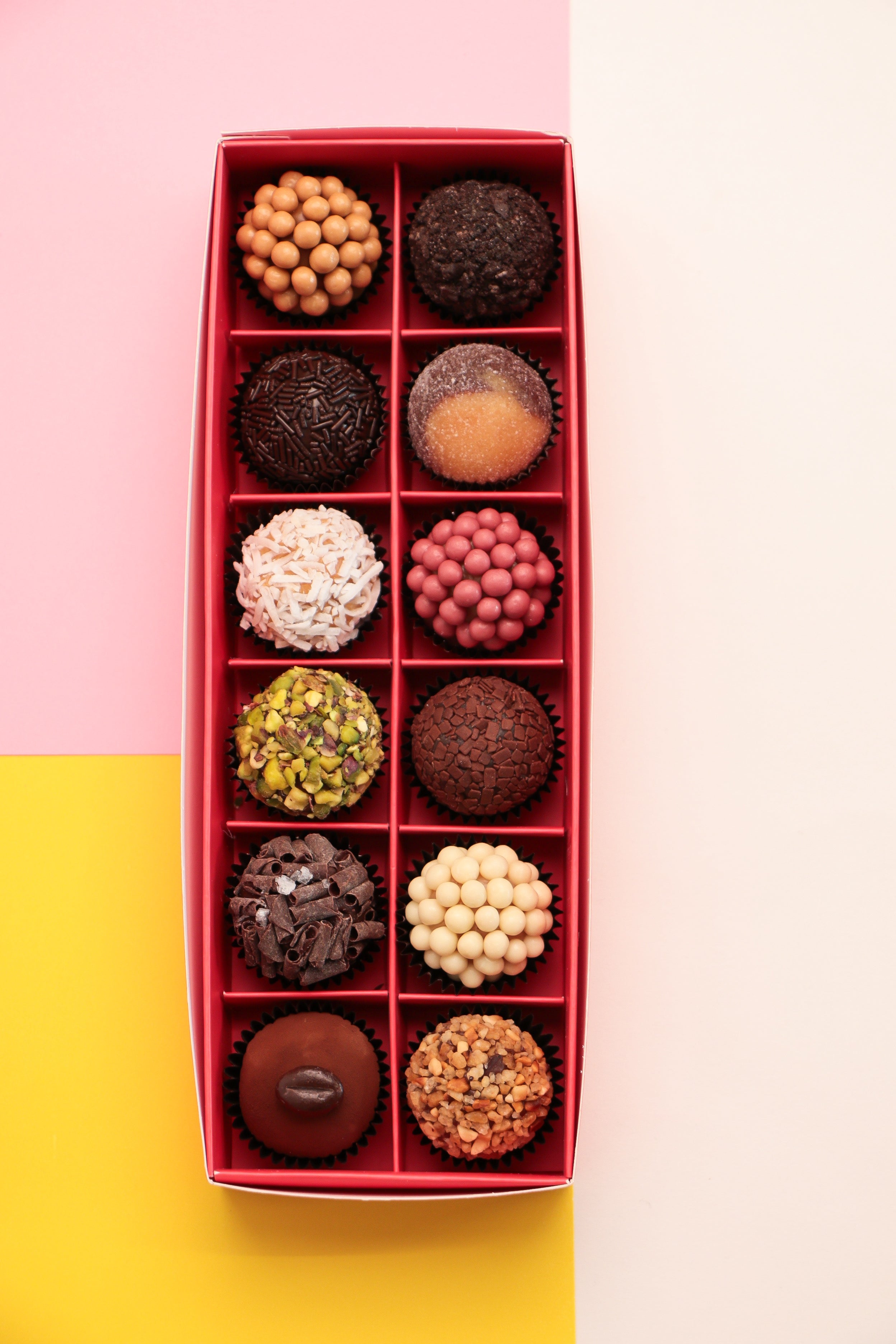 Box of assorted 12 pieces Brigadeiro chocolates with a decorative box on a colorful background