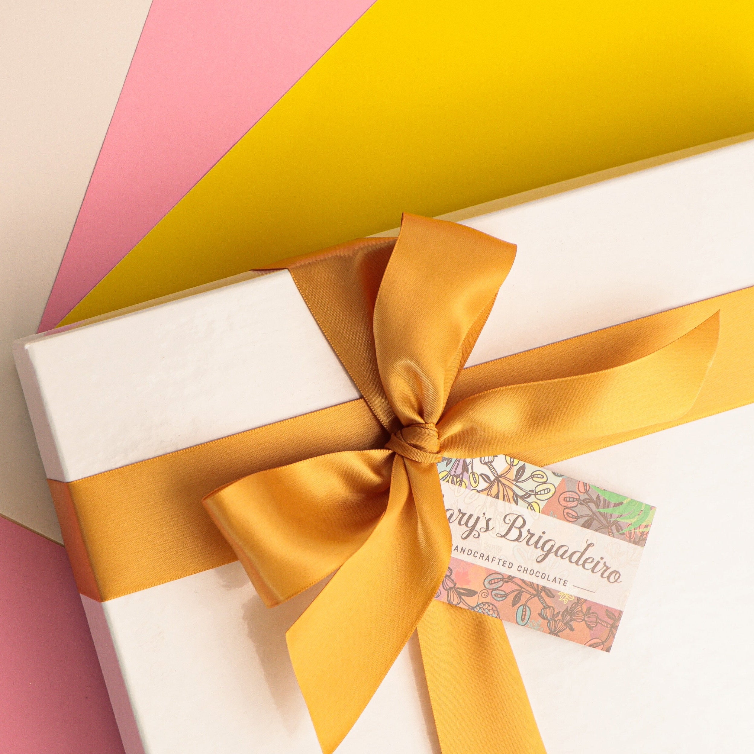 White gift box with a yellow ribbon on a colorful background